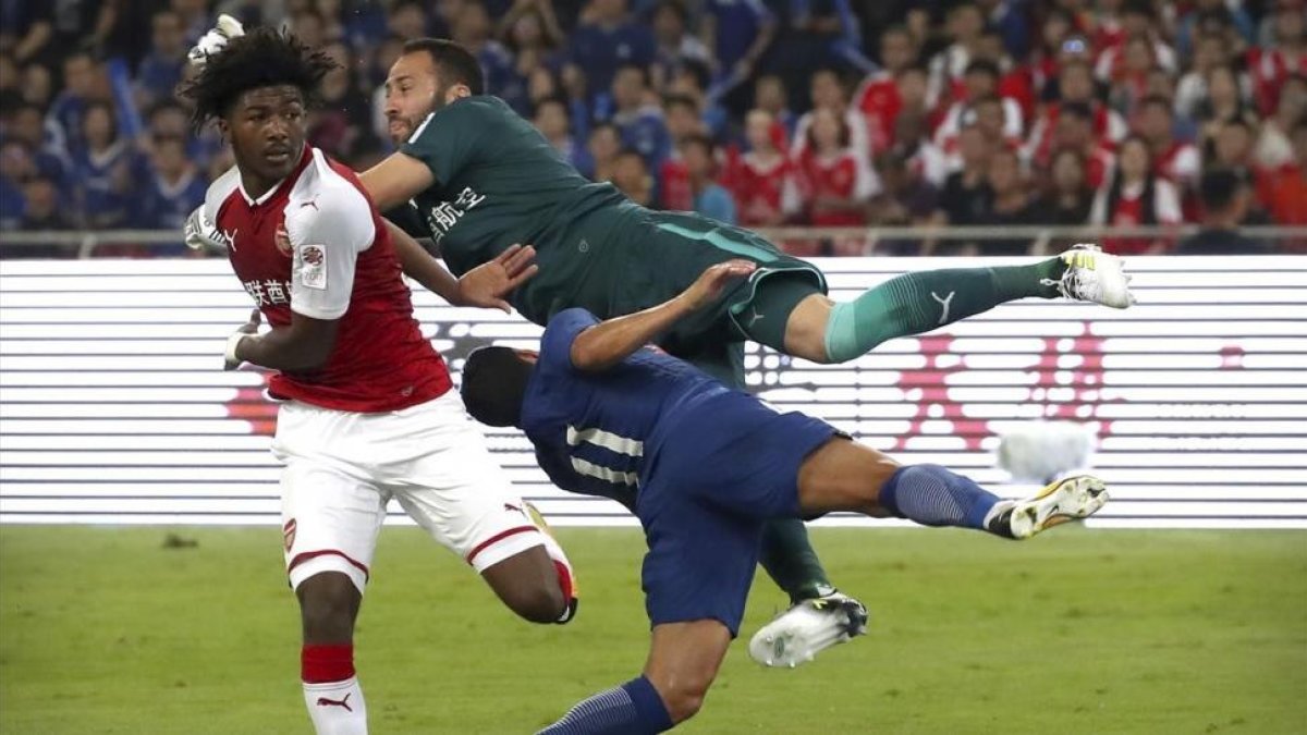David Ospina, el portero del Arsenal, arrolla a Pedro, del Chelsea.-AP / MARK SCHIEFELBEIN