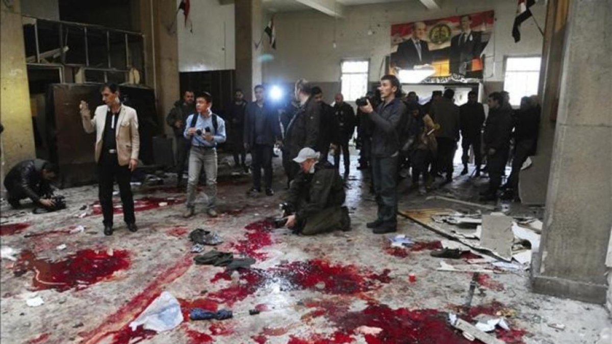 Varios periodistas inspeccionan el lugar de un atentado suicida en el Palacio de Justicia de Damasco (Siria), el pasado 15 de marzo.-EFE