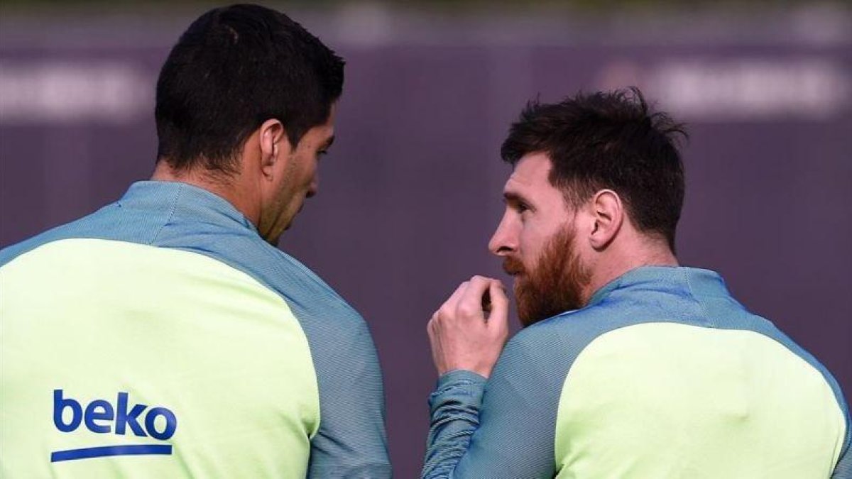 Messi y Suárez conversan en una sesión de entrenamiento del Barcelona.-AFP / LLUIS GENE