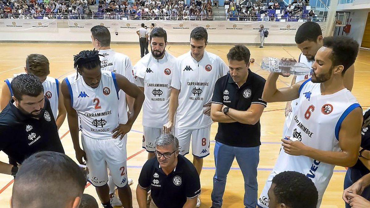 Paco García, pizarra en mano, alecciona a sus jugadores en un tiempo muerto.-J.M. LOSTAU