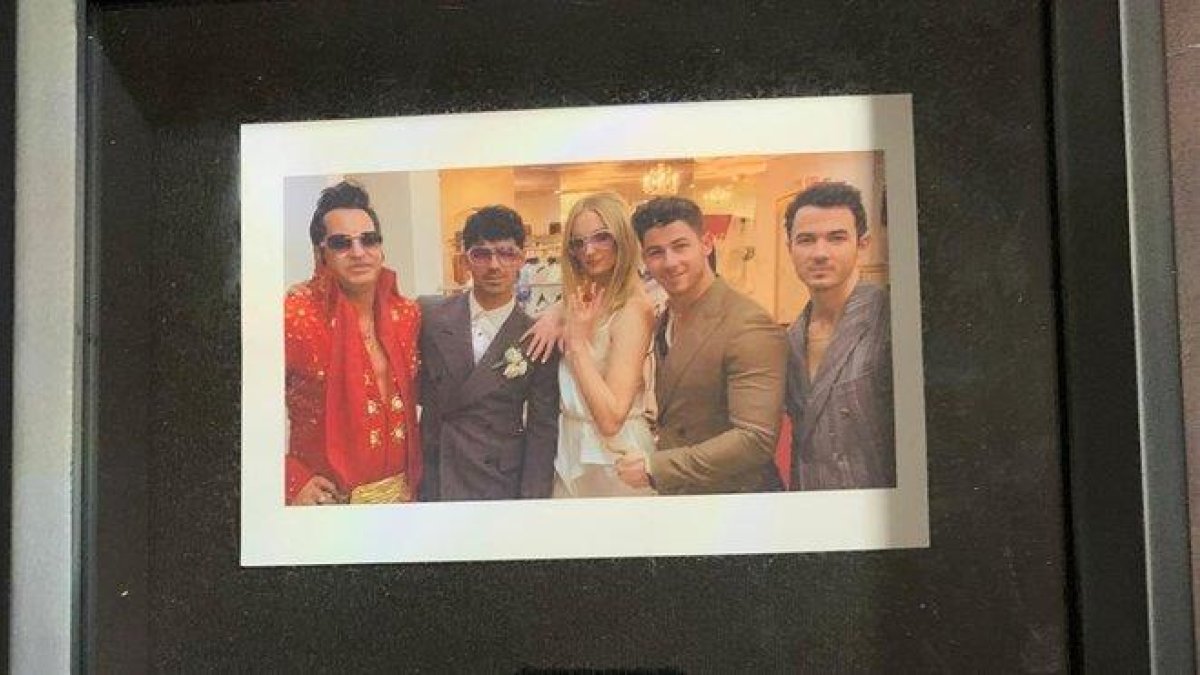 Detalle de la foto enmarcada de la boda de Joe Jonas y Sophie Turner, con el Elvis Presley que ofició la ceremonia y Kevin y Nick Jonas.-JESSE GARON (REUTERS)