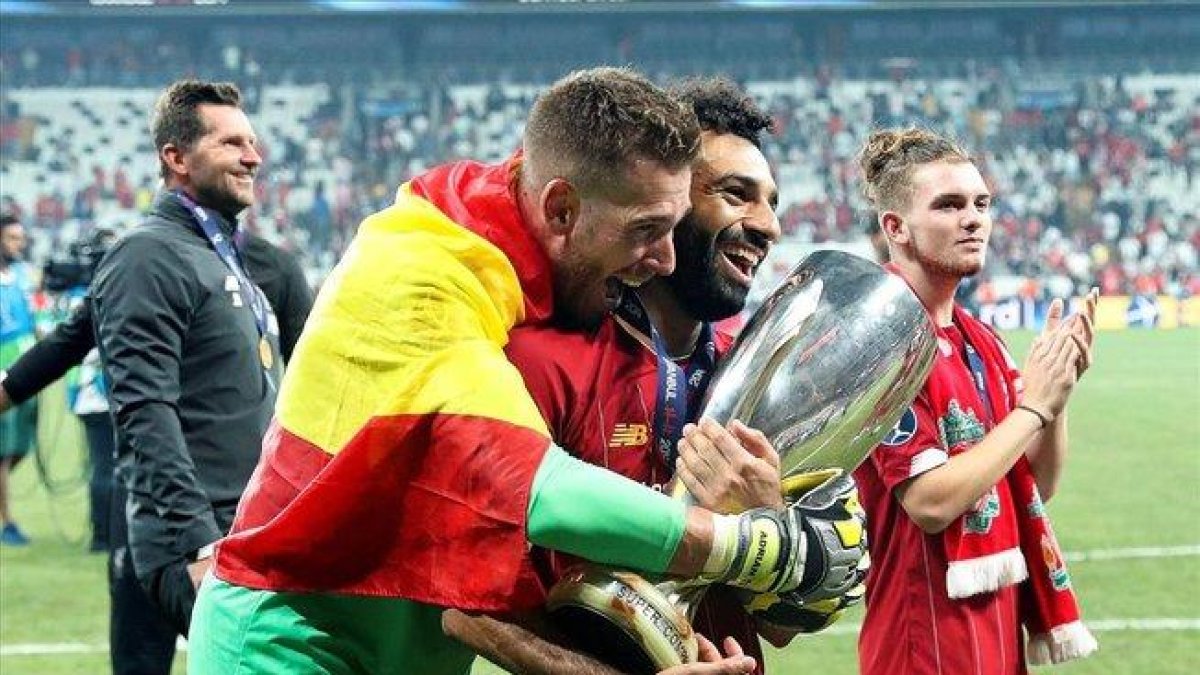 El guardameta Adrián San Miguel, abrazado a Salah que sostiene el trofeo de la Supercopa-EFE (TOLGA BOZOGLU)