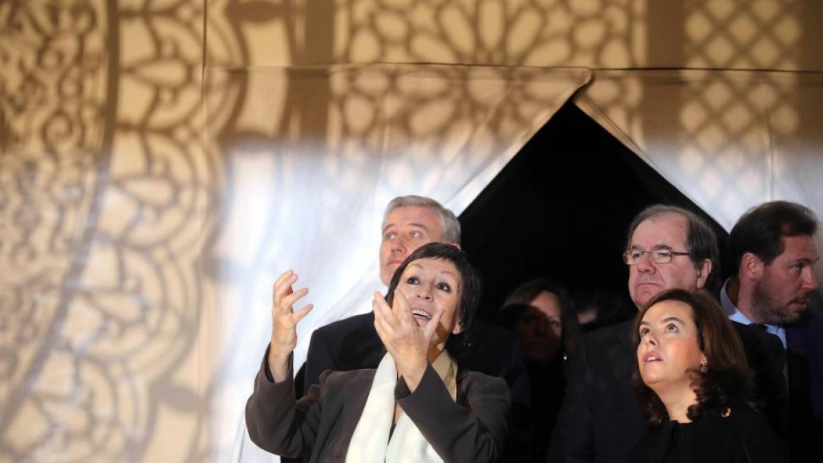 La vicepresidenta del Gobierno, Soraya Sáenz de Santamaría, visita la exposición 'Nada temas, dice ella' acompañada del presidente de la Junta, Juan Vicente Herrera. En la imagen, junto a la comisaria de la muestra, Rosa Martínez, observan la obra 'Inters-ICAL