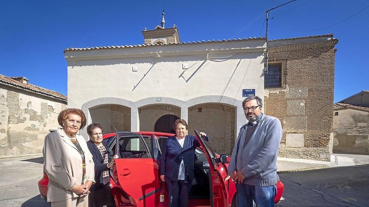 María del Carmen Ramos, María Benita Aguado y Manuela Galán, en el coche del sacerdote, Ramón Peláez, frente a la iglesia de Fuente-Olmedo.-MIGUEL ÁNGEL SANTOS