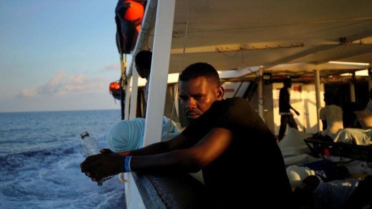 Un migrante en la cubierta del Open Arms.-JUAN MEDINA (REUTERS)