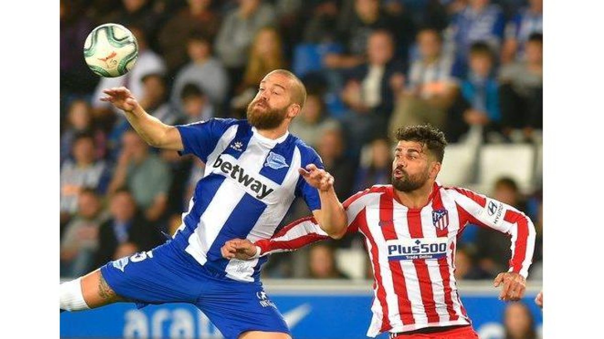 El atlético Diego Costa disputa un balón aéreo ante Laguardia en el partido ante el Alavés.-AFP