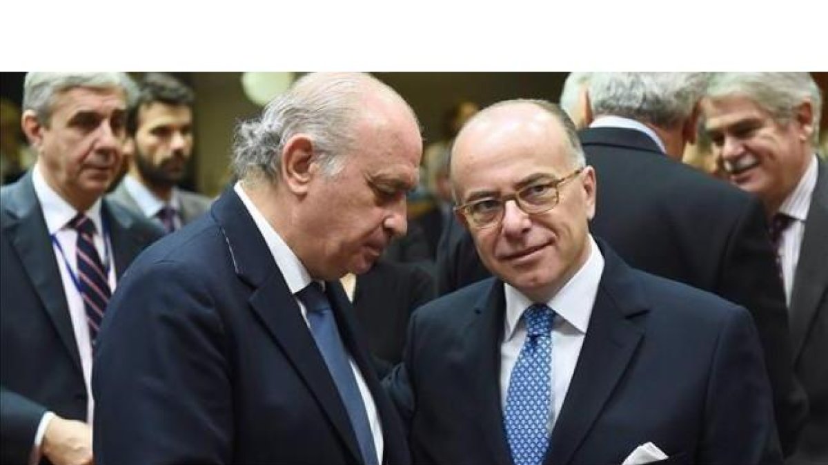Fernández Díaz (izquierda) conversa con su homólogo francés, Bernard Cazeneuve, este viernes en Bruselas.-AFP / EMMANUEL DUNAND
