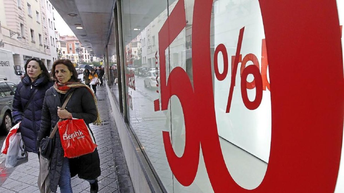 Dos clientas caminan por una céntrica calle de Valladolid tras realizar sus primeras compras de rebajas.-J.M. Lostau