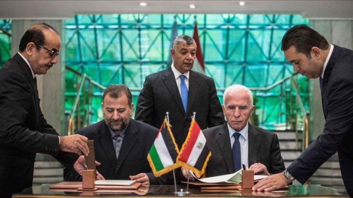 El representante de Fatá, Azam al Ahmad (derecha) y el de Hamás, Saleh al Arouri, firman el acuerdo en El Cairo.-AFP / KHALED DESOUKI