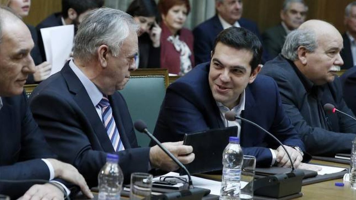 Tsipras (segundo por la derecha) habla con el viceprimer ministro, Yannis Dragasakis, en la primera reunión del Consejo de Ministros, este miércoles en Atenas.-Foto: AP / PETROS GIANNAKOURIS