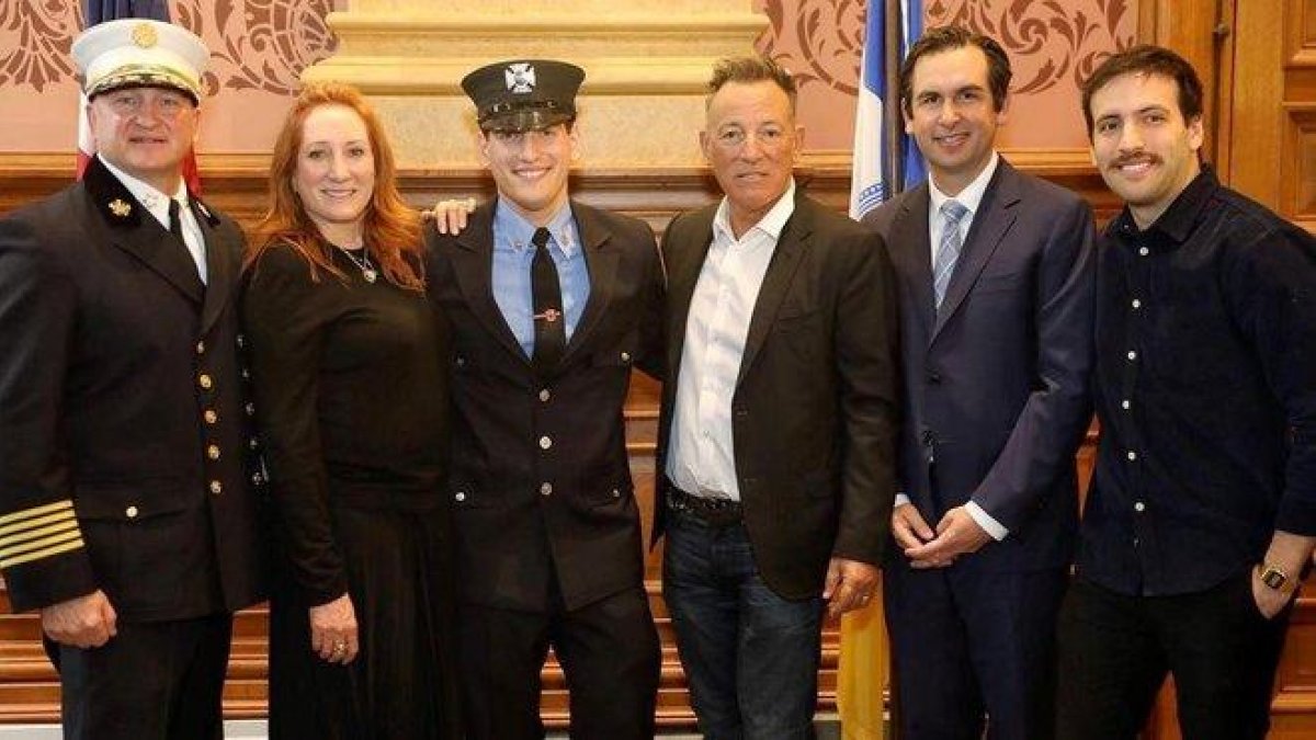La estrella de rock Bruce Springsteen (3d) su esposa Patti Scialfa (2i) su hijo Evan (d) el alcalde de Jersey City Steven Fulop (2i) y el jefe de bomberos de la ciudad Steven McGill (i) mientras posan junto a su hijo menor Sam (3i).-Foto cedida por el Ayuntamiento de Jersey City