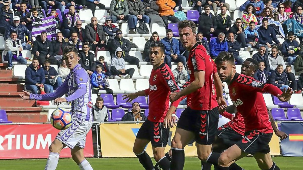 Juan Villar observa la trayectoria del balón ante la presencia de tres jugadores del Nàstic.-PABLO REQUEJO (PHOTOGENIC)