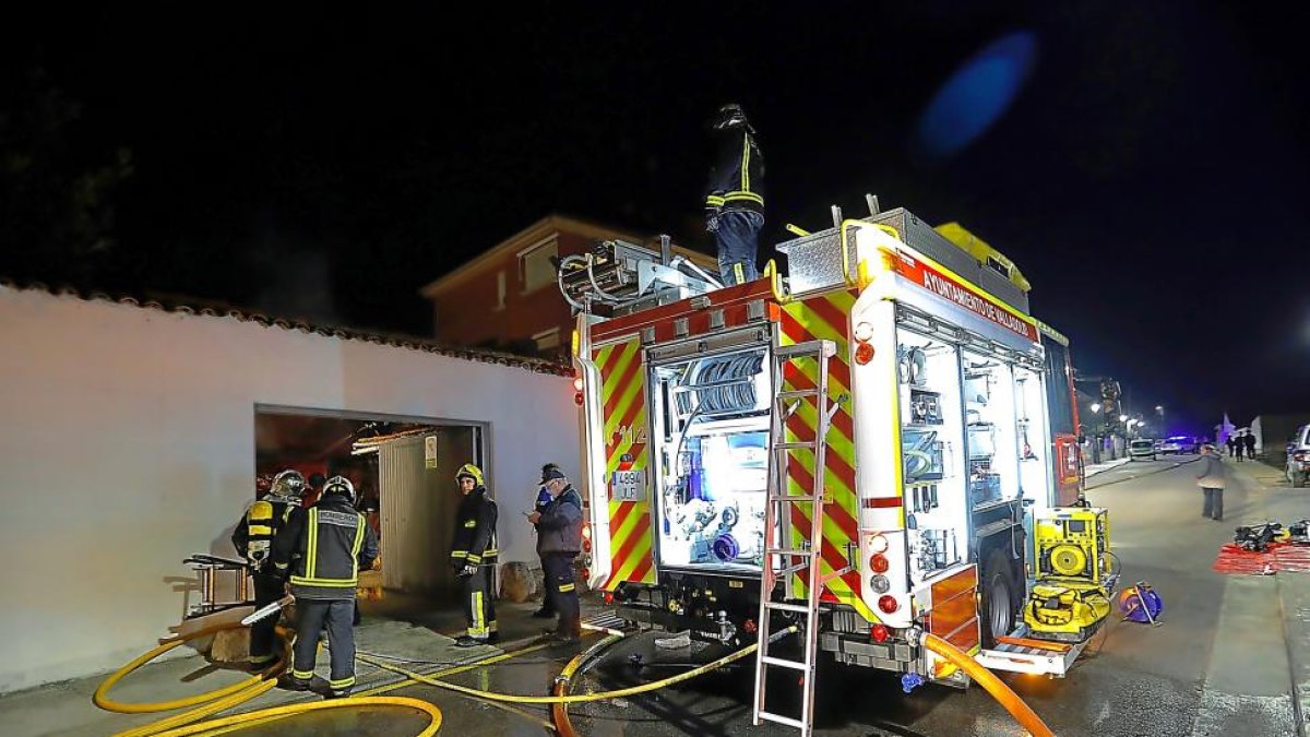 Los bomberos, trabajando para apagar el fuego del garaje.-J. M. LOSTAU