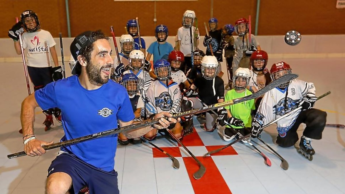 Olmo Ercilla realiza un truco con el disco ante la mirada de varios jugadores a los que entrena.-J.M. LOSTAU
