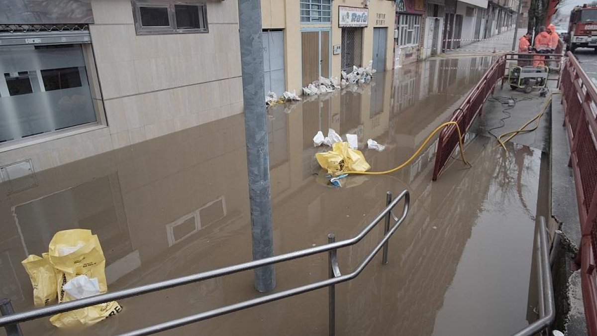 Una calle inundada en Miranda con sacos para frenar en agua en los negocios.-ECB