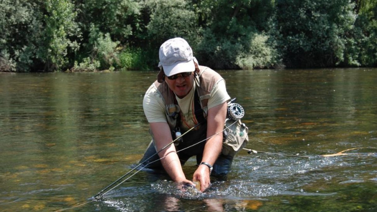 Un aficionado devolviendo una captura en un tramo del río Tormes-LEONARDO DE LA FUENTE