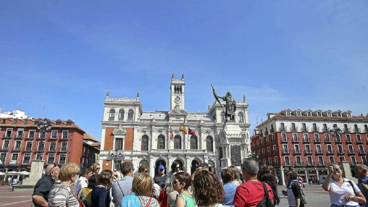 Un grupo de visitantes atiende a las explicaciones del guía en la Plaza Mayor.-ICAL