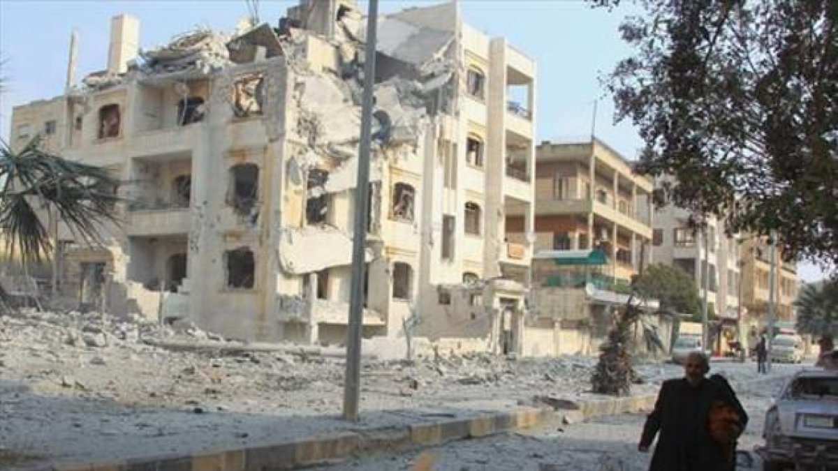 Un hombre camina entre edificios dañados por los bombardeos rusos en la ciudad siria de Idleb.-REUTERS / AMMAR ABDULLAH
