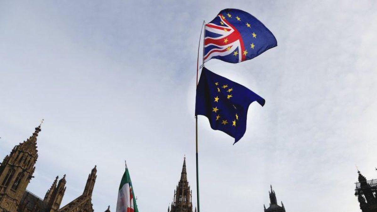 Un manifestante sostiene las bandera de Gran Bretaña y de la UE en una protesta ante el Parlamento británico, en Londres.-FRANK AUGSTEIN (AP)