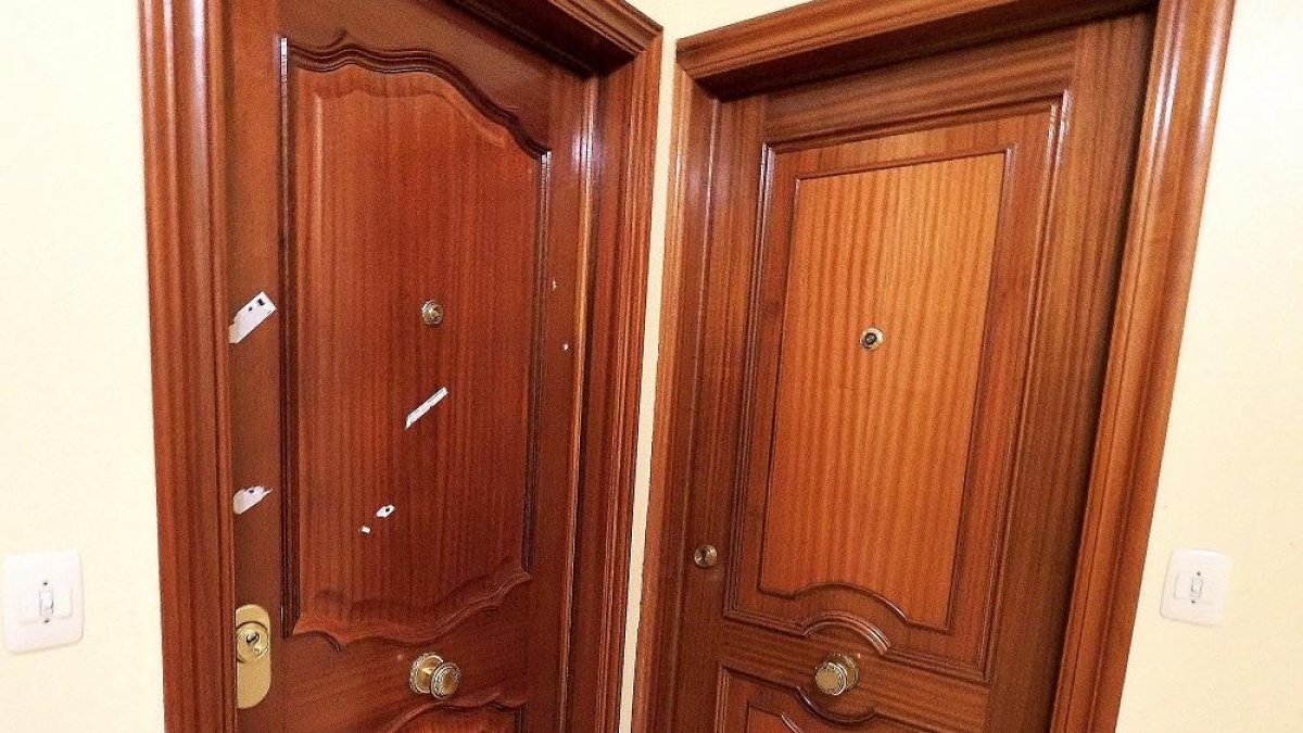 Puerta de la vivienda del número 17 de la calle Industrias en la que se produjo la agresión, con restos de los rótulos adhesivos policiales.-P. REQUEJO