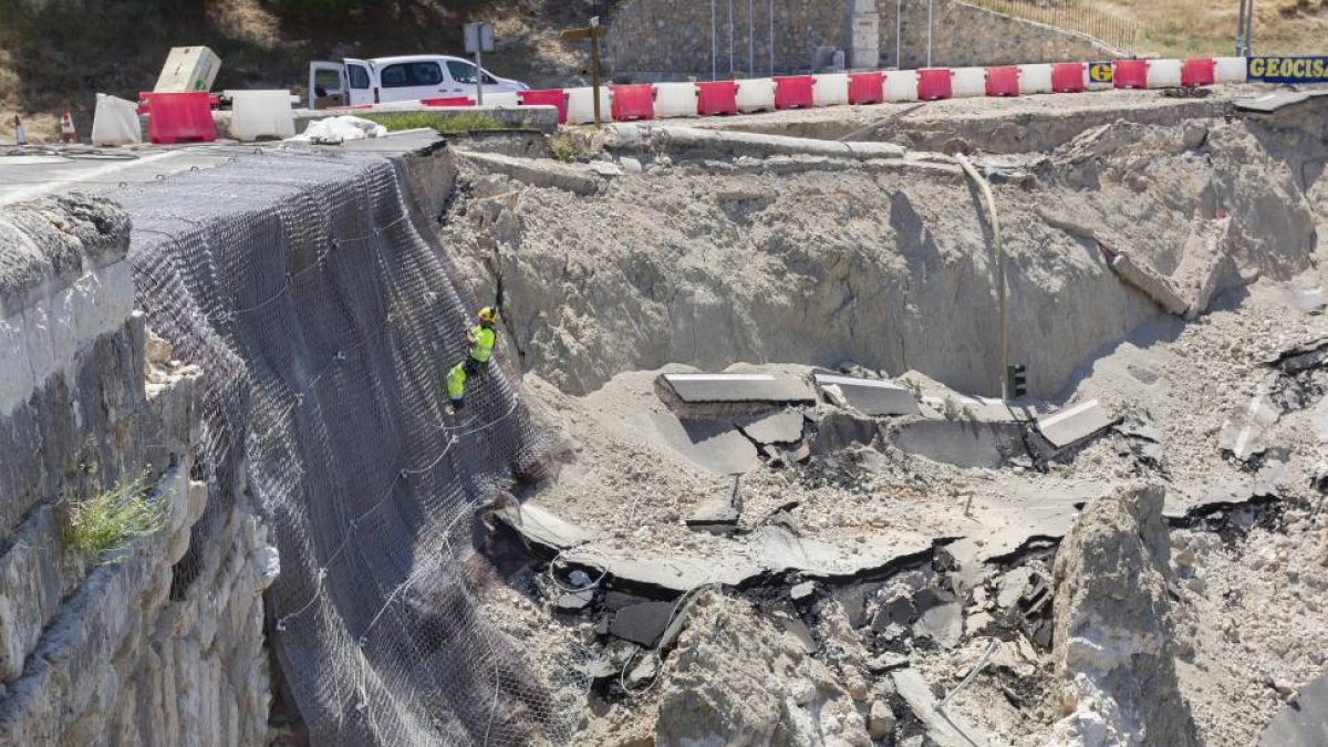 Un operario trabaja en la instalación de la malla que protege el primer arco del puente.-Pablo Requejo