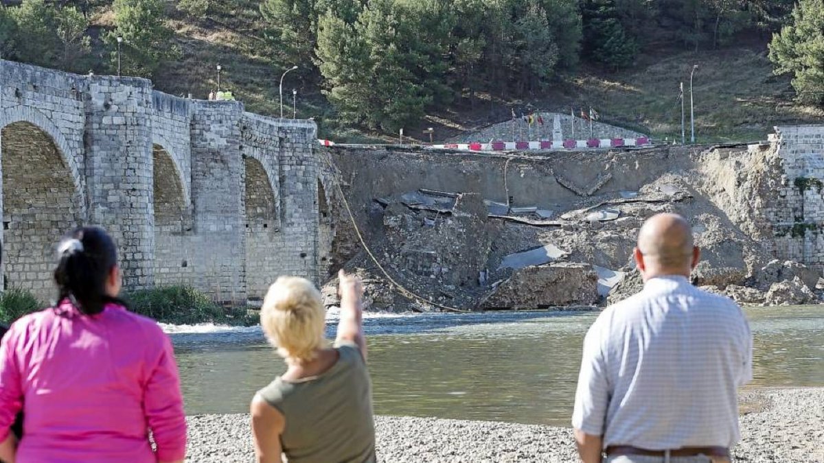 Tres vecinos de cabezón observan el estado en el que ha quedado el puente.-Miguel Ángel Santos