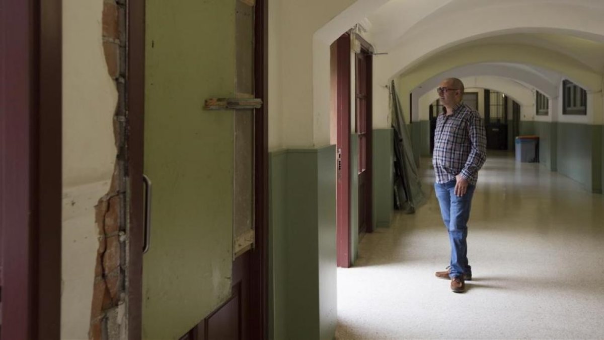 El director del colegio Ramon Llull de Barcelona, Manuel Lombardía, muestra los daños causados por la Policía Nacional en el centro.-ALBERT BERTRAN