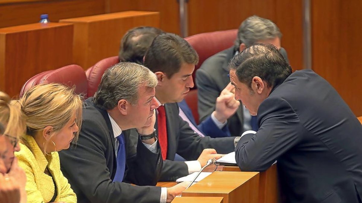 El Consejero de Sanidad, Antonio Sáez Aguado, habla con procuradores de la bancada popular, ayer en las Cortes.-ICAL
