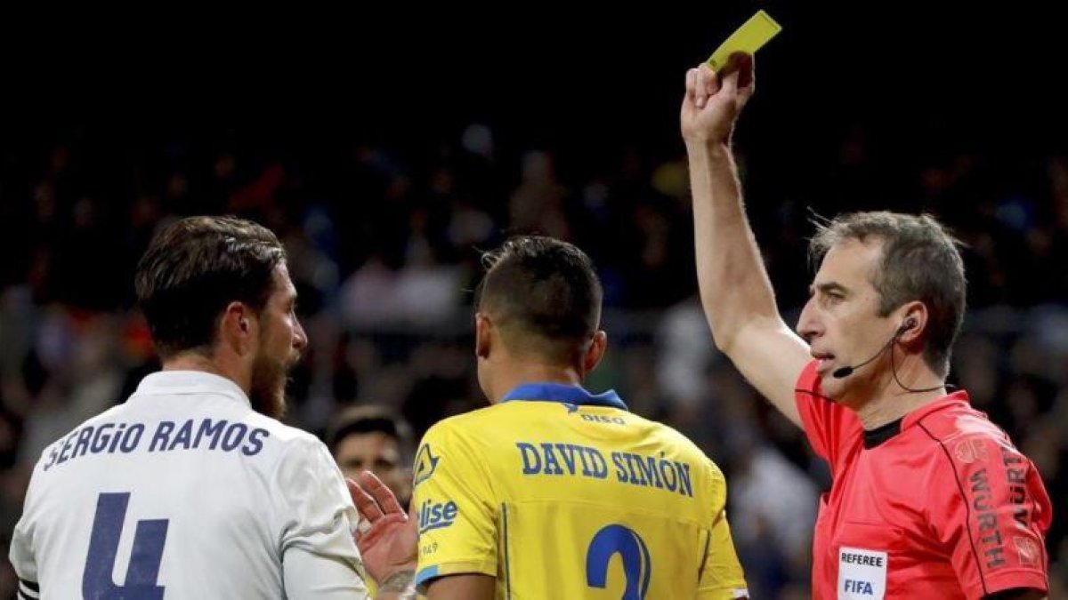 Fernández Borbalán amonesta a Sergio Ramos durante el partido.-EFE / JUANJO MARTÍN