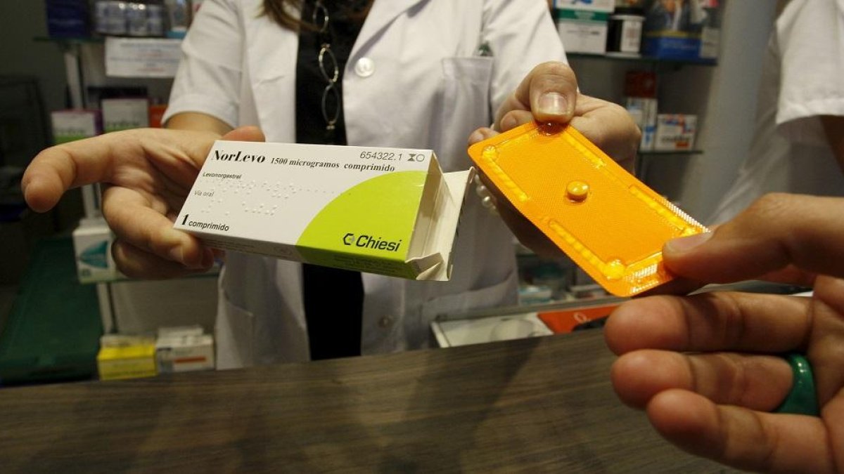 Una farmaceútica entrega un medicamento.-E.M.