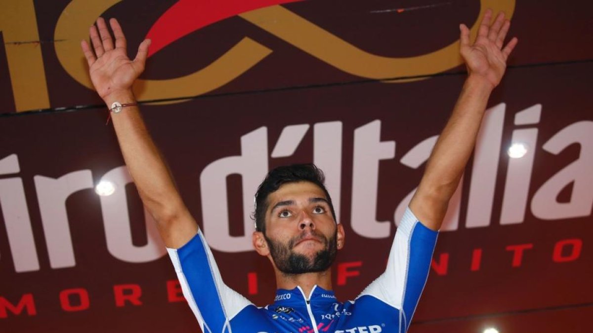 Fernando Gaviria celebra el triunfo en el podio del Giro.-LUK BENIES