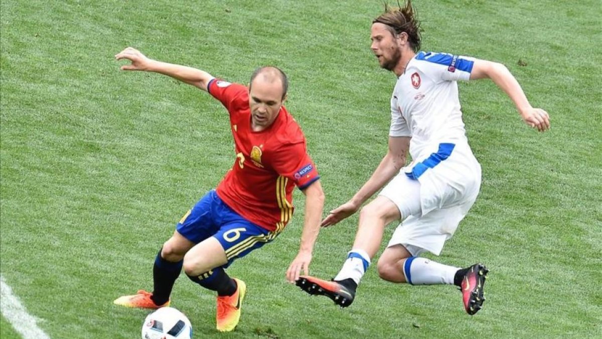 Iniesta se intenta escapar de la presión de Plasil.-AFP / PASCAL PAVANI