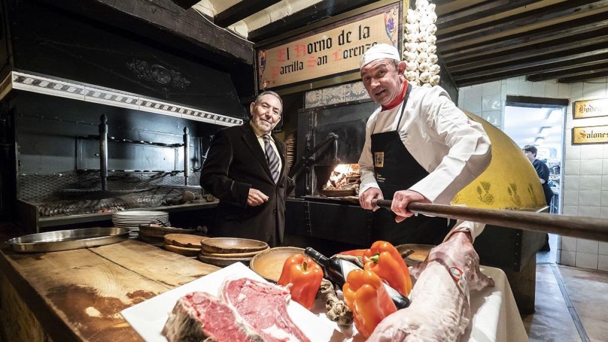 Agustín Lorenzo Sanz, propietario del establecimiento, junto a Eugenio Ugidos, maestro asador que lleva 30 años de servicio en el restaurante.-PABLO REQUEJO