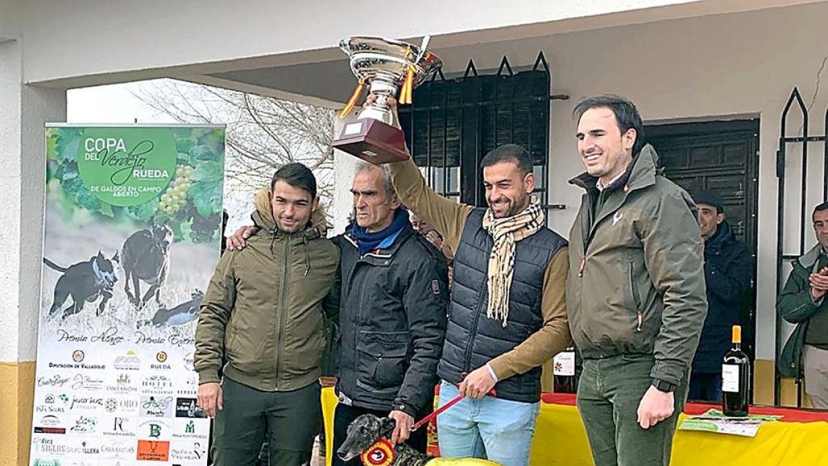 El equipo ganador posa con la galga ‘Flecha’, la copa recibida y el alcalde de la villa, Guzmán Gómez.-EL MUNDO
