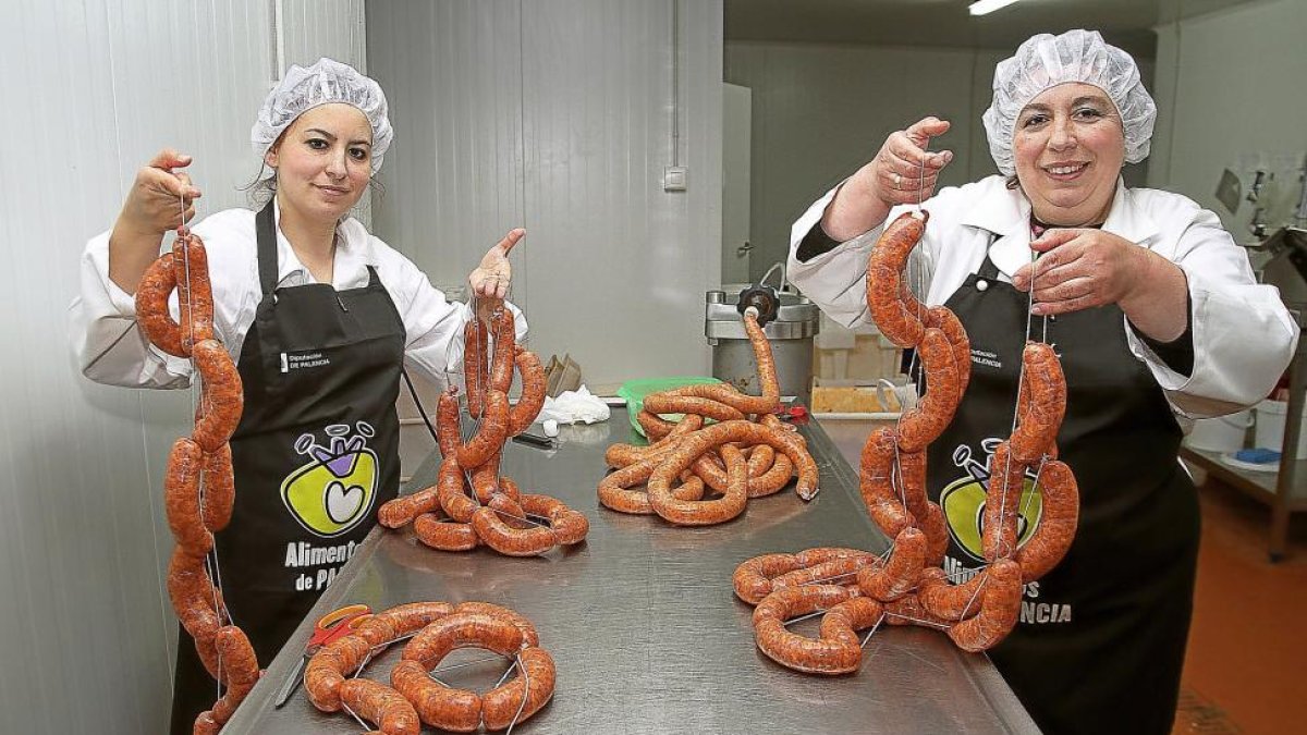 Sonia y Clara Bezos muestran sonrientes ristras de chorizos.-BRÁGIMO