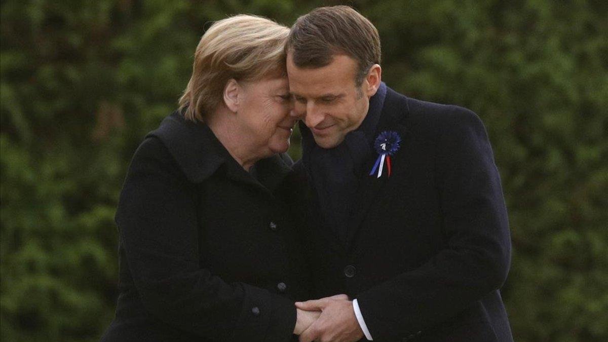 Merkel y Macron se abrazan tras descubrir una placa durante una ceremonia conmemorativa por el Armisticio, en Compiegne, Francia-PHILLIPPE WOJAZER