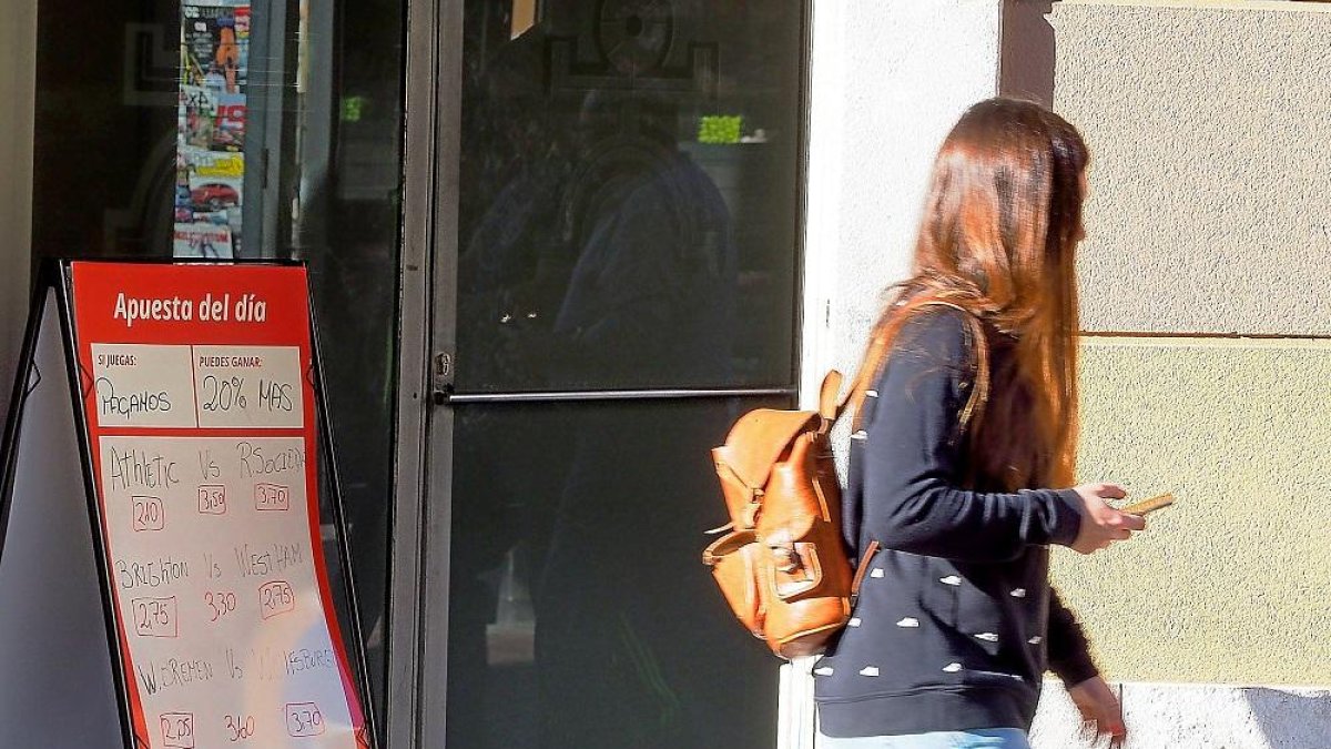 Una chica pasa por delante de un local de apuestas en Valladolid.-PABLO REQUEJO