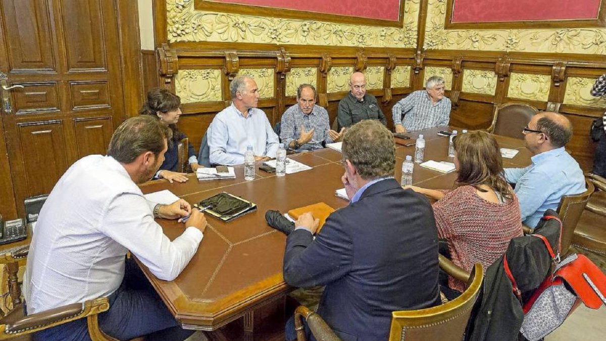 Puente y Saravia, de espaldas, escuchan la intervención de Parellada en la reunión.-Miguel Ángel Santos