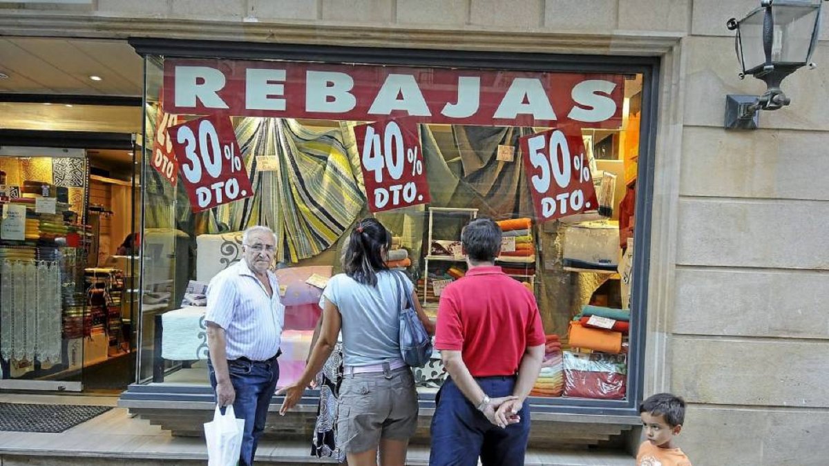 Un escaparate con carteles de rebajas en Soria.-Valentín Guisande