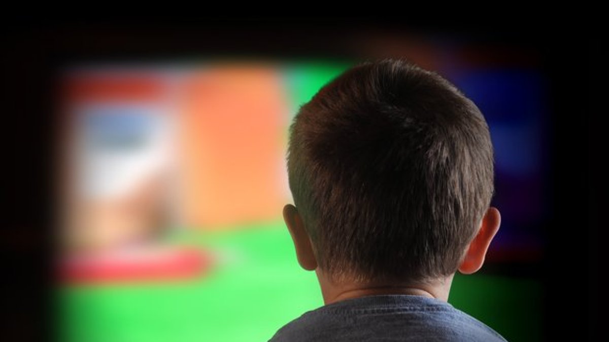 Un niño mira la televisión.-123RF
