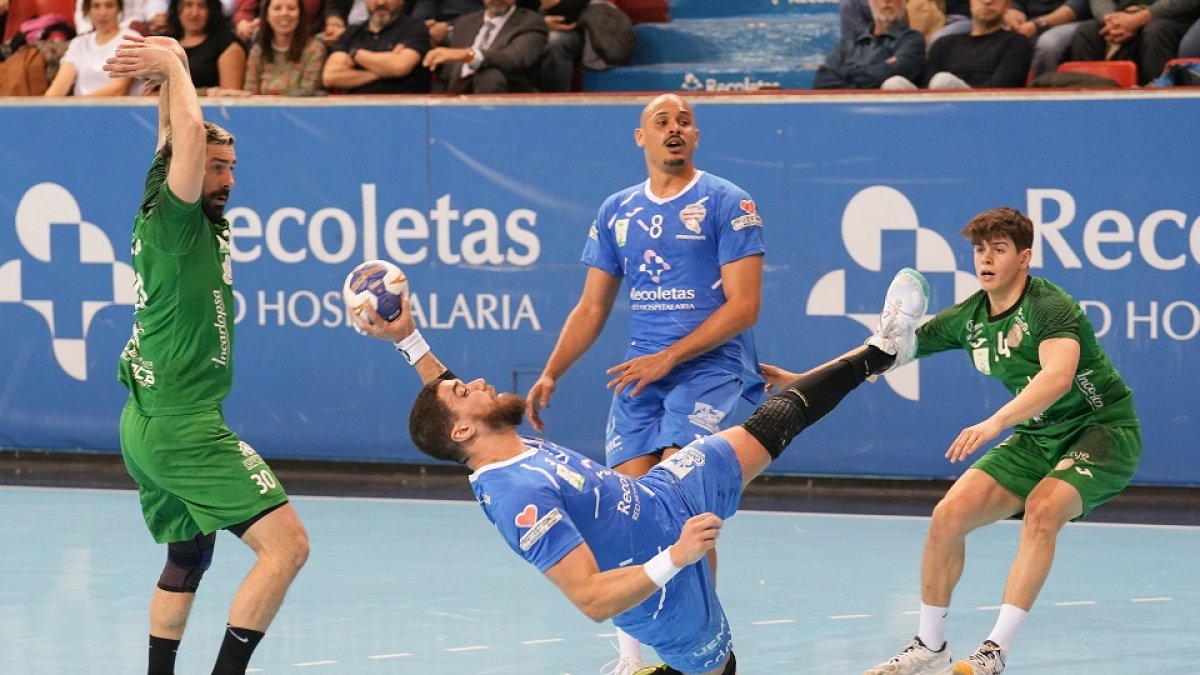 De Toledo intenta lanzar de forma acrobática ante la mirada impotente de la defensa del BM Cuenca./ J. M. LOSTAU