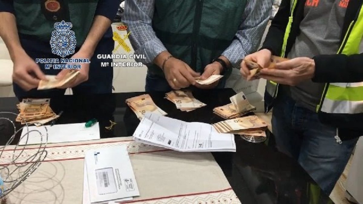 Agentes de la Guardia Civil y de la Policía Nacional cuentan el dinero intervenido en la operación.- GUARIA CIVIL