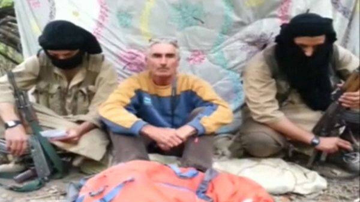El turista francés, que se autoidentifica como Hervé Gourdel, sentado en medio de sus secuestradores, en una imagen de vídeo.-Foto: REUTERS TV