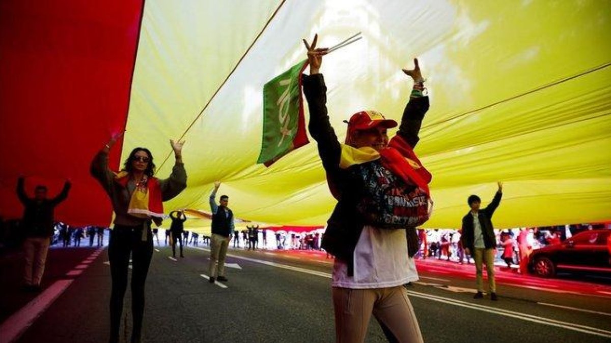 Voluntarios de Vox conducen una bandera de España de 1.000 metros cuadrados al acto del partido en la Plaza de Colón.-EFE / DAVID FERNÁNDEZ