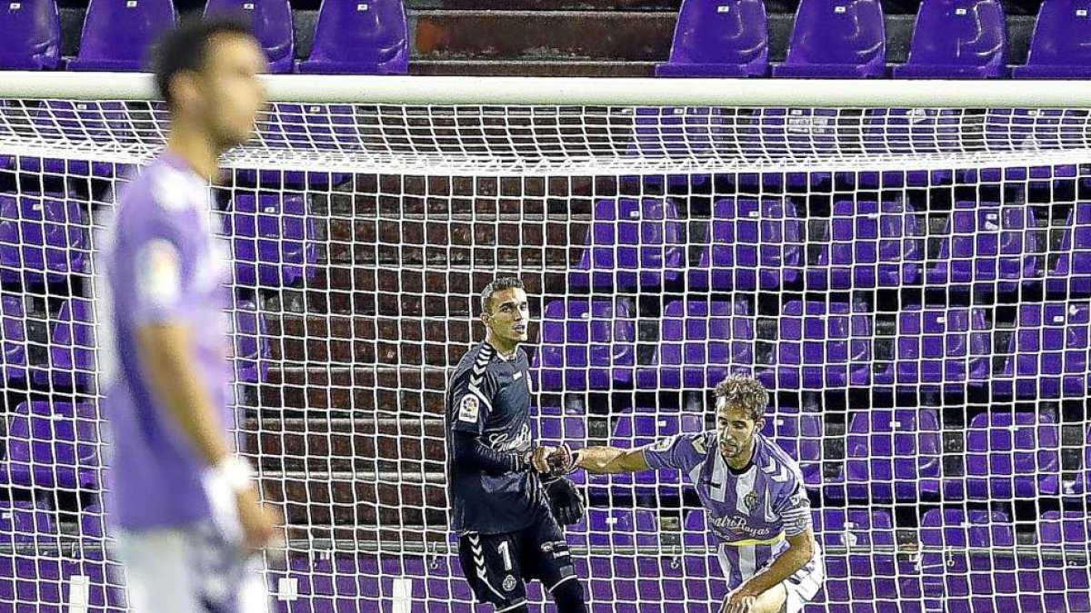 El portero Masip ayuda a levantarse al defensa  Ángel tras uno de los tres goles del Nàstic.-J.M. LOSTAU