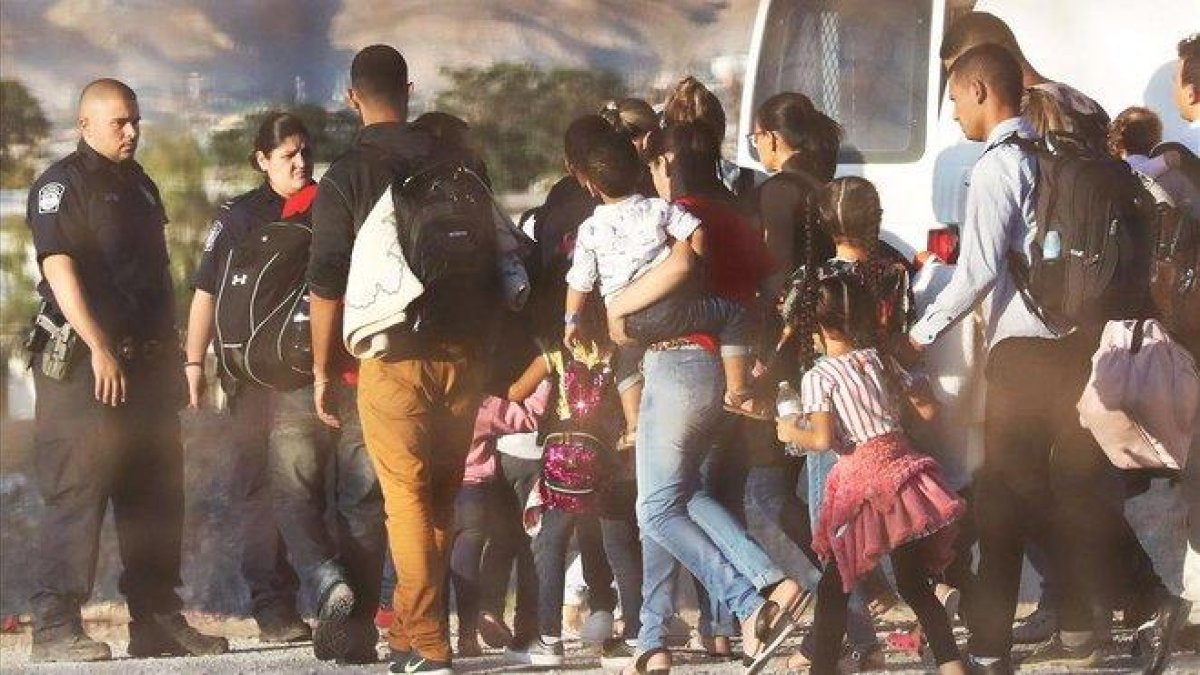Policías estadounidenses custodian a un grupo de inmigrantes que han sido detenidos por entrar ilegalmente en EEUU.-AFP / MARIO TAMA