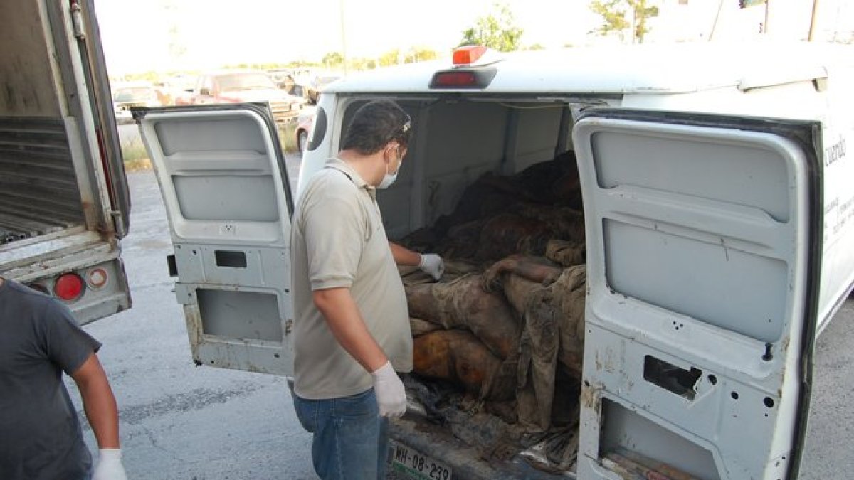 Peritos forenses descargan uno de los cadáveres hallados en las fosas clandestinas encontradas en Veracruz.-EFE