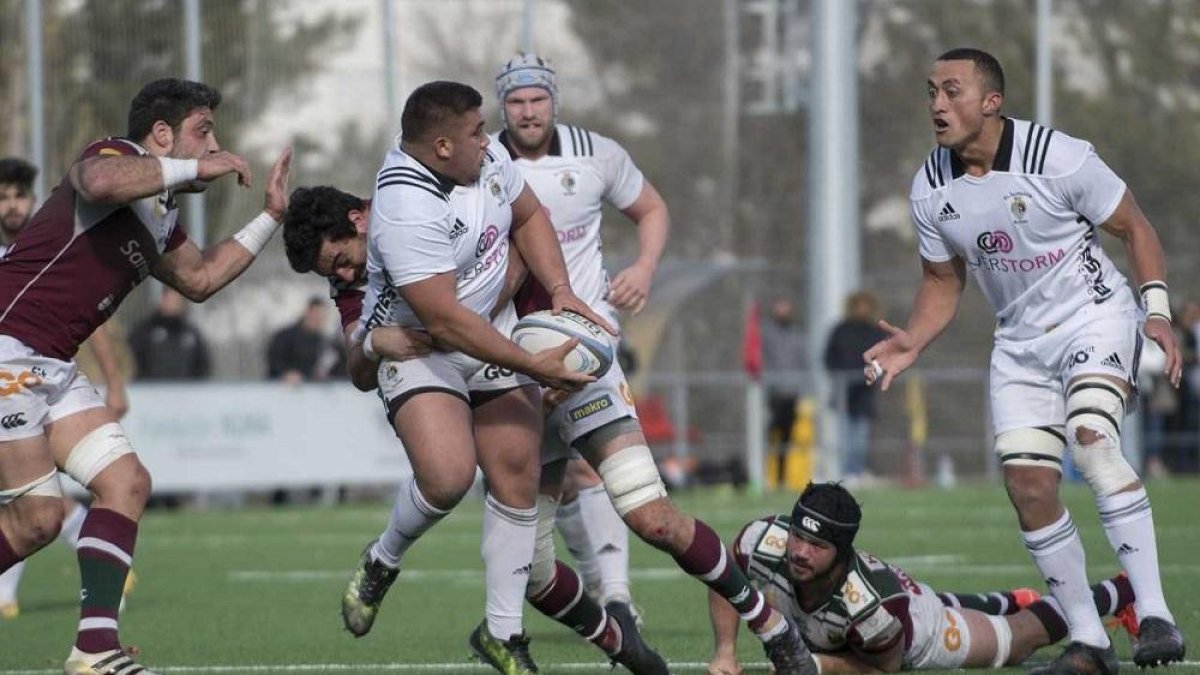 Nicolás Jurado pasa el oval a Sione Teu ante el placaje del Sanitas Alcobendas, ayer, en Las Terrazas.-JL USEROS