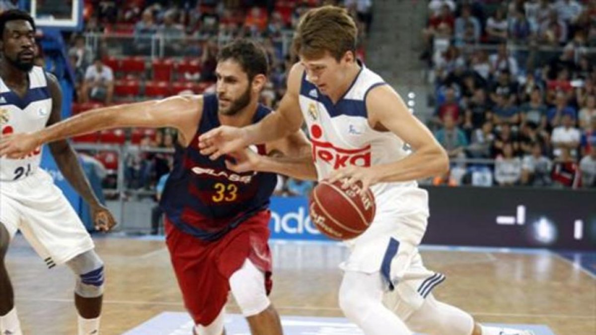 Doncic conduce el balón presionado por el azulgrana Perperoglou en un reciente Barça-Madrid-EFE / DAVID AGUILAR