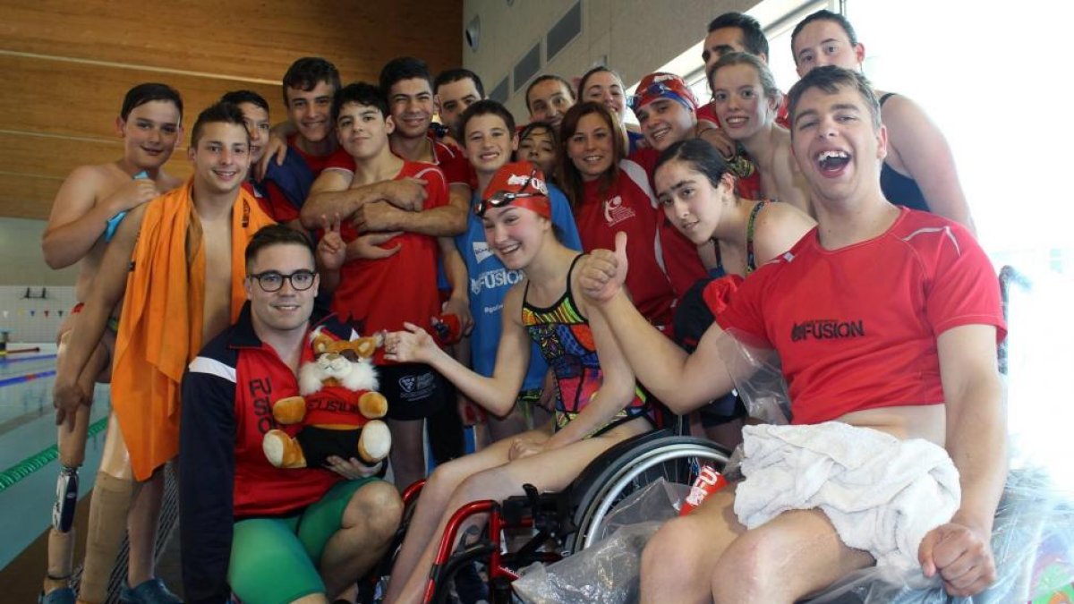 Varios de los nadadores del club posan con la mascota del Fusión, un lince, tras una competición.-EL MUNDO